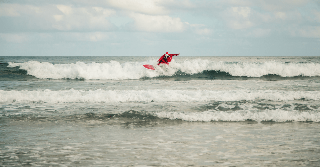 Santa surfing in the ocean
